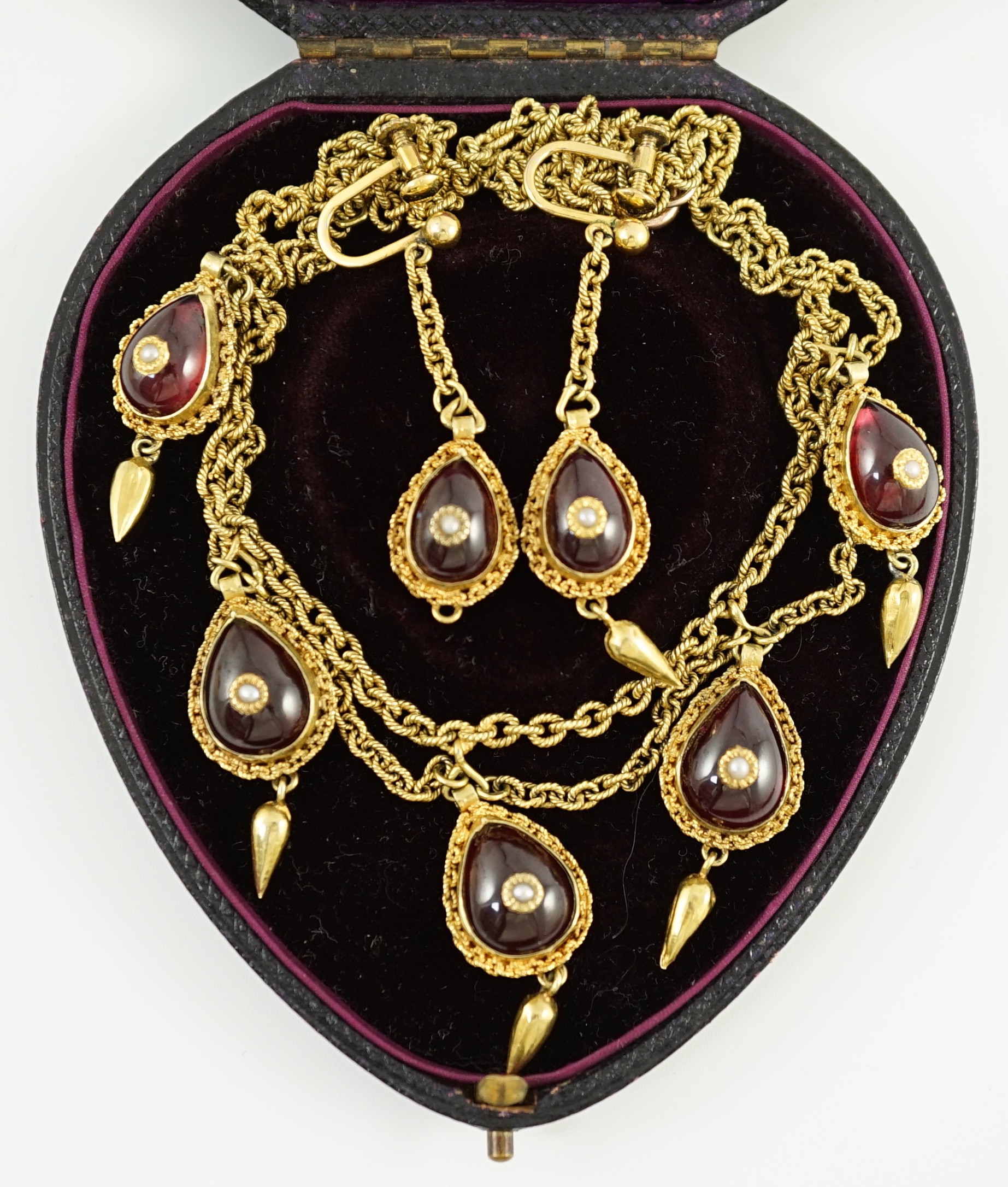 A 19th century Indian gold, garnet and seed pearl set demi parure, comprising and a drop fringe necklace and pair of matching ear clips